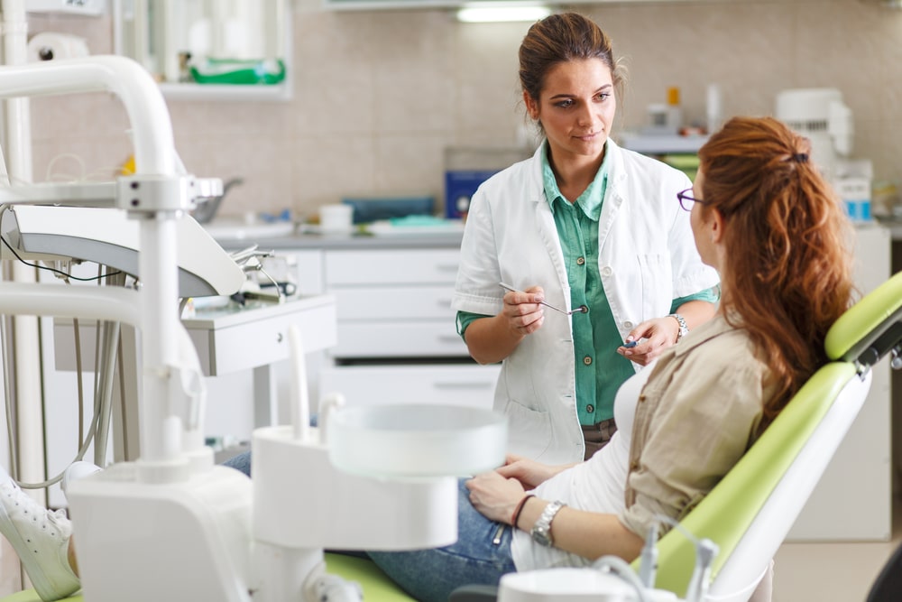 A woman talking to a dental professional.