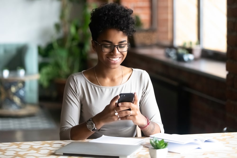 A woman using a phone at her desk